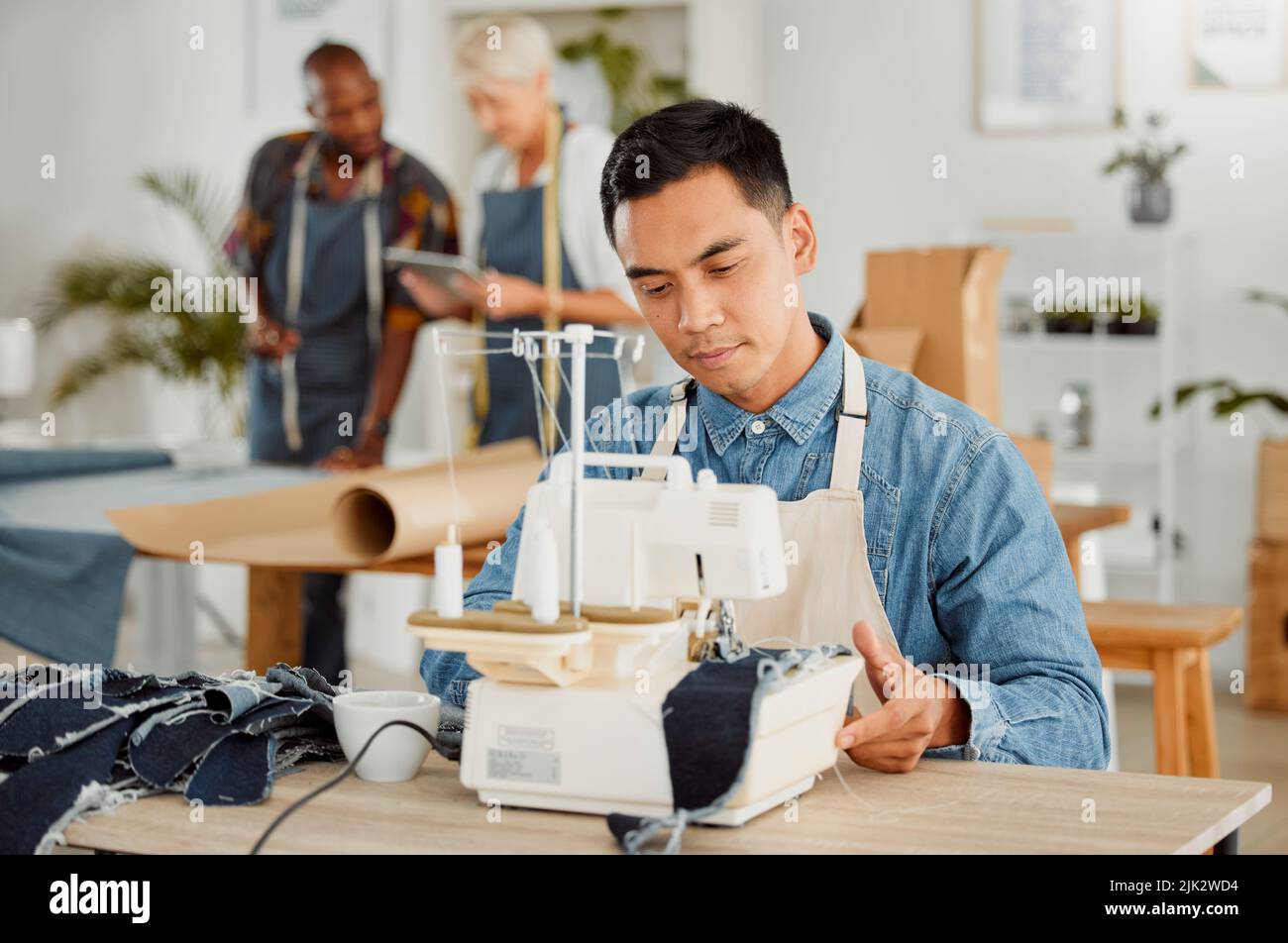 Cucire su misura e fare abiti con la macchina per cucire in moda, design e laboratorio creativo. Uomo serio che lavora a mano, alla moda e alla moda Foto Stock