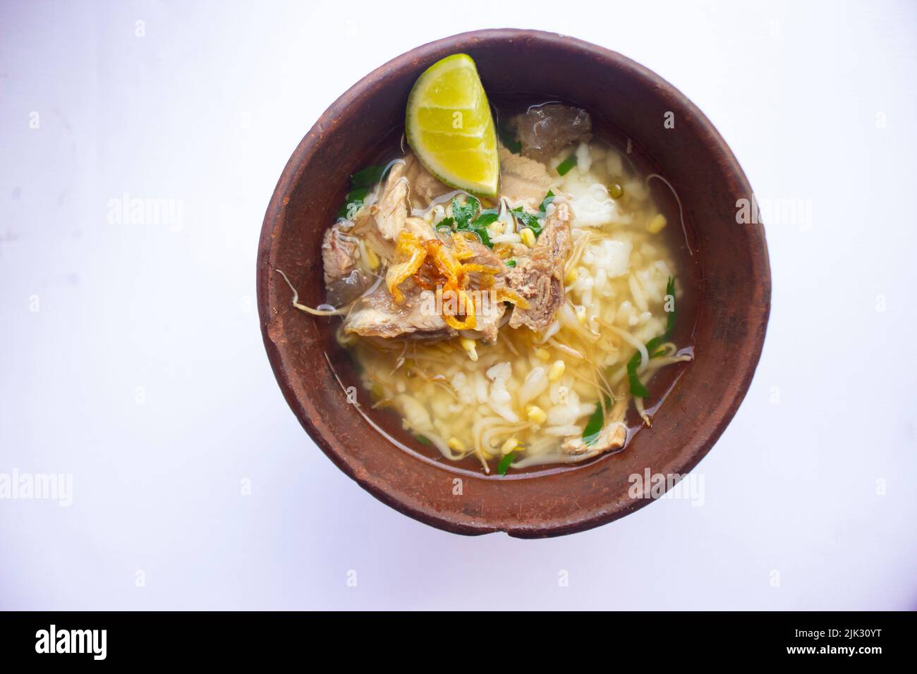 soto kwali. isolato su sfondo bianco. Zuppa di manzo giavanese limpida con germogli di manzo, lime e riso; servita in una ciotola tradizionale di kwali (un con Foto Stock