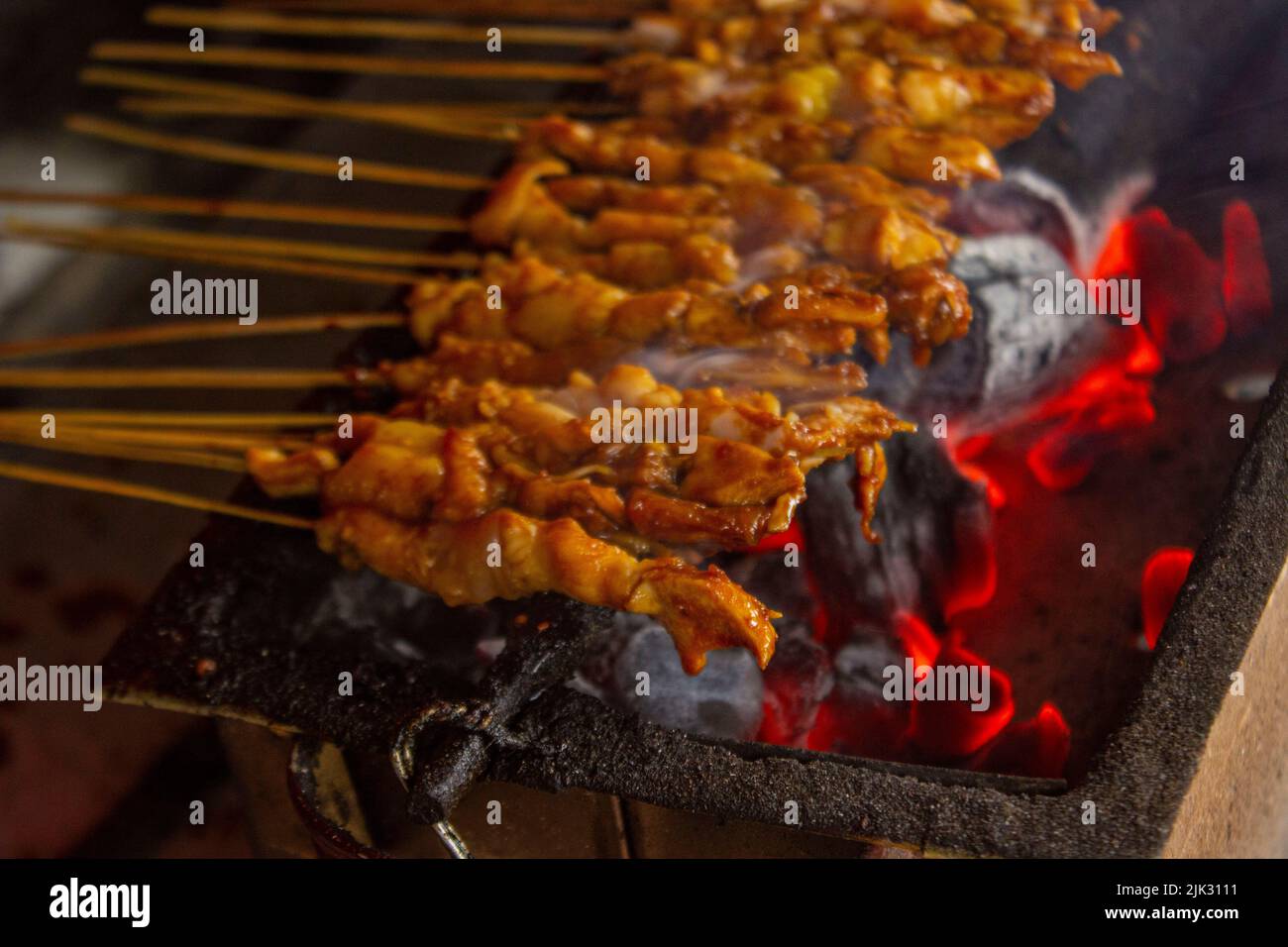 sate ayam o satay di pollo , o satay di pollo o carne con ingrediente di carbone sul fuoco rosso che grigliano da People. Satay tradizionale da, Indonesia Foto Stock