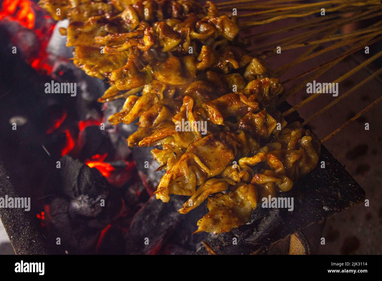 sate ayam o satay di pollo , o satay di pollo o carne con ingrediente di carbone sul fuoco rosso che grigliano da People. Satay tradizionale da, Indonesia Foto Stock