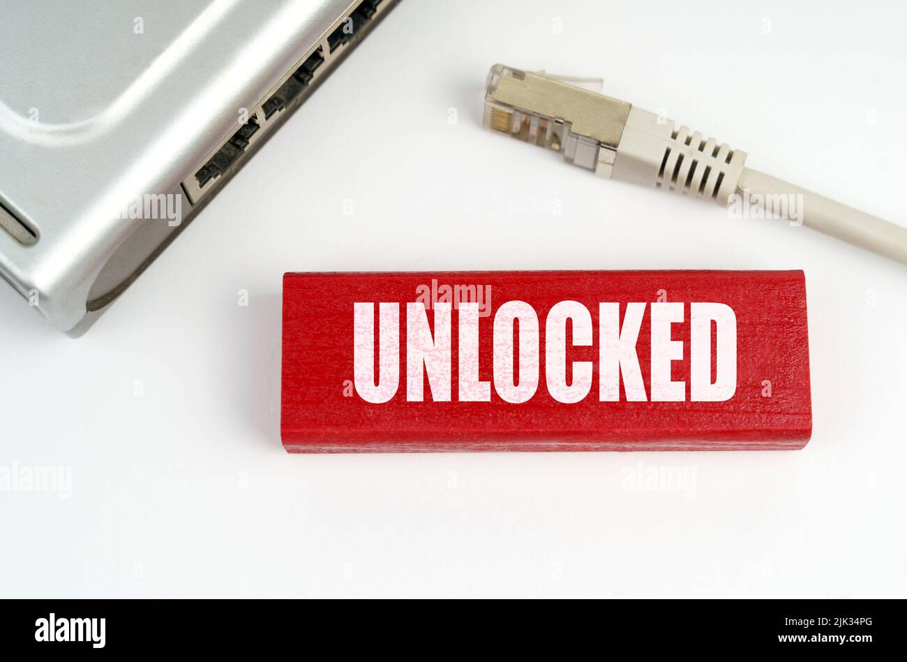 Internet e concetto di sicurezza. Sul tavolo è presente un router disconnesso dalla rete, accanto a una targhetta con l'iscrizione - sbloccato Foto Stock