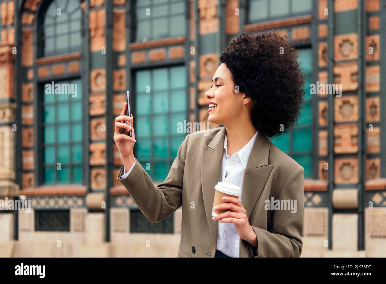 donna sorridente felice di fare una videochiamata all'aperto Foto Stock