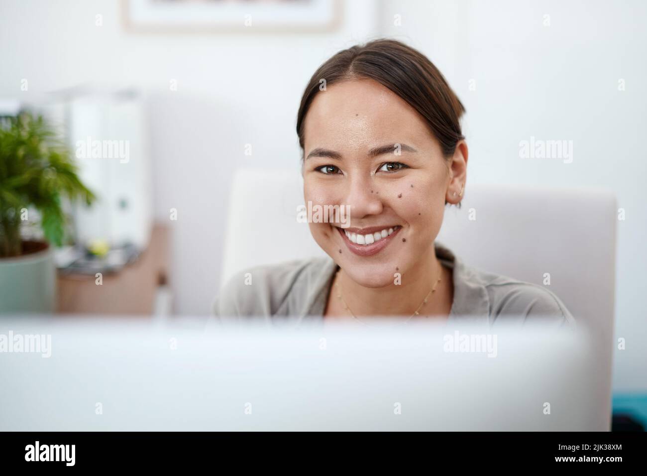 Essere in vendita di veicoli è il mio sogno. Una giovane donna d'affari nel suo ufficio utilizzando il suo computer. Foto Stock