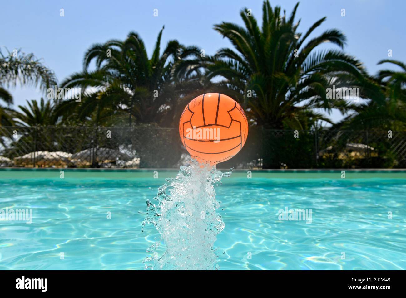 volare su palla arancione dalla piscina Foto Stock