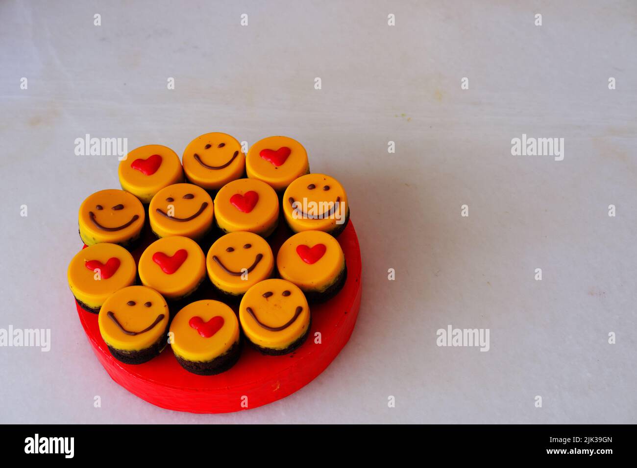 Piccole torte gialle a forma di focolare e sorridenti Foto Stock
