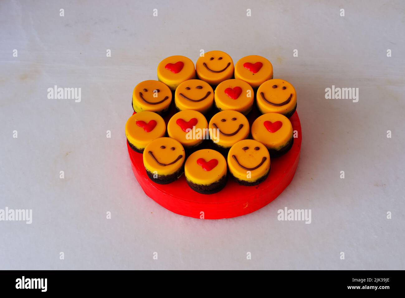 Piccole torte gialle a forma di focolare e sorridenti Foto Stock