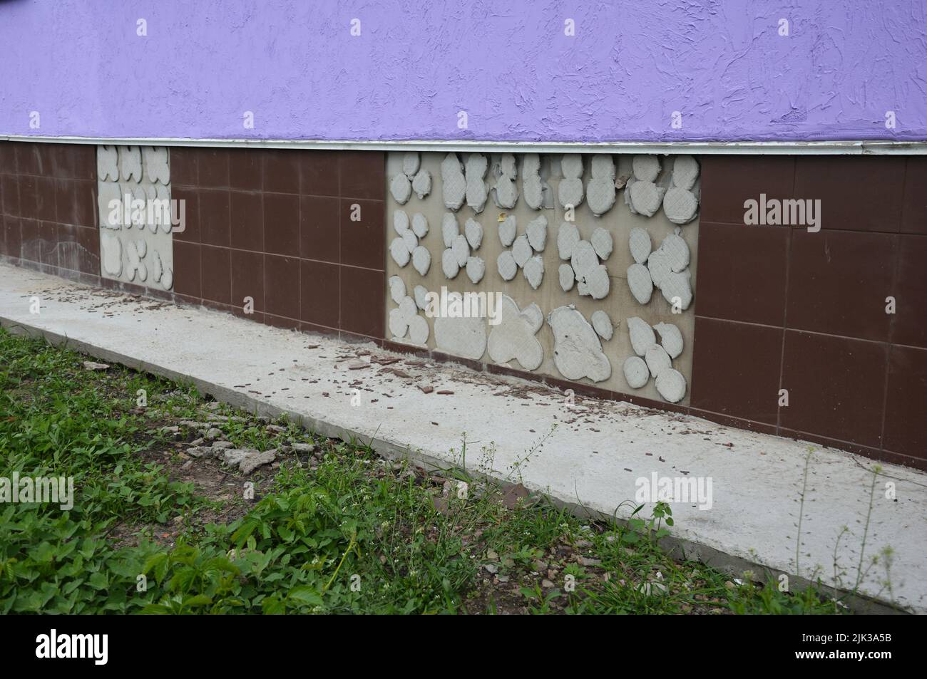 Scivolato, rotto, caduto da piastrelle di ceramica, piastrelle di muro mancanti su una parete di fondazione casa causata dal seminterrato, fondazione problemi di impermeabilizzazione. Foto Stock