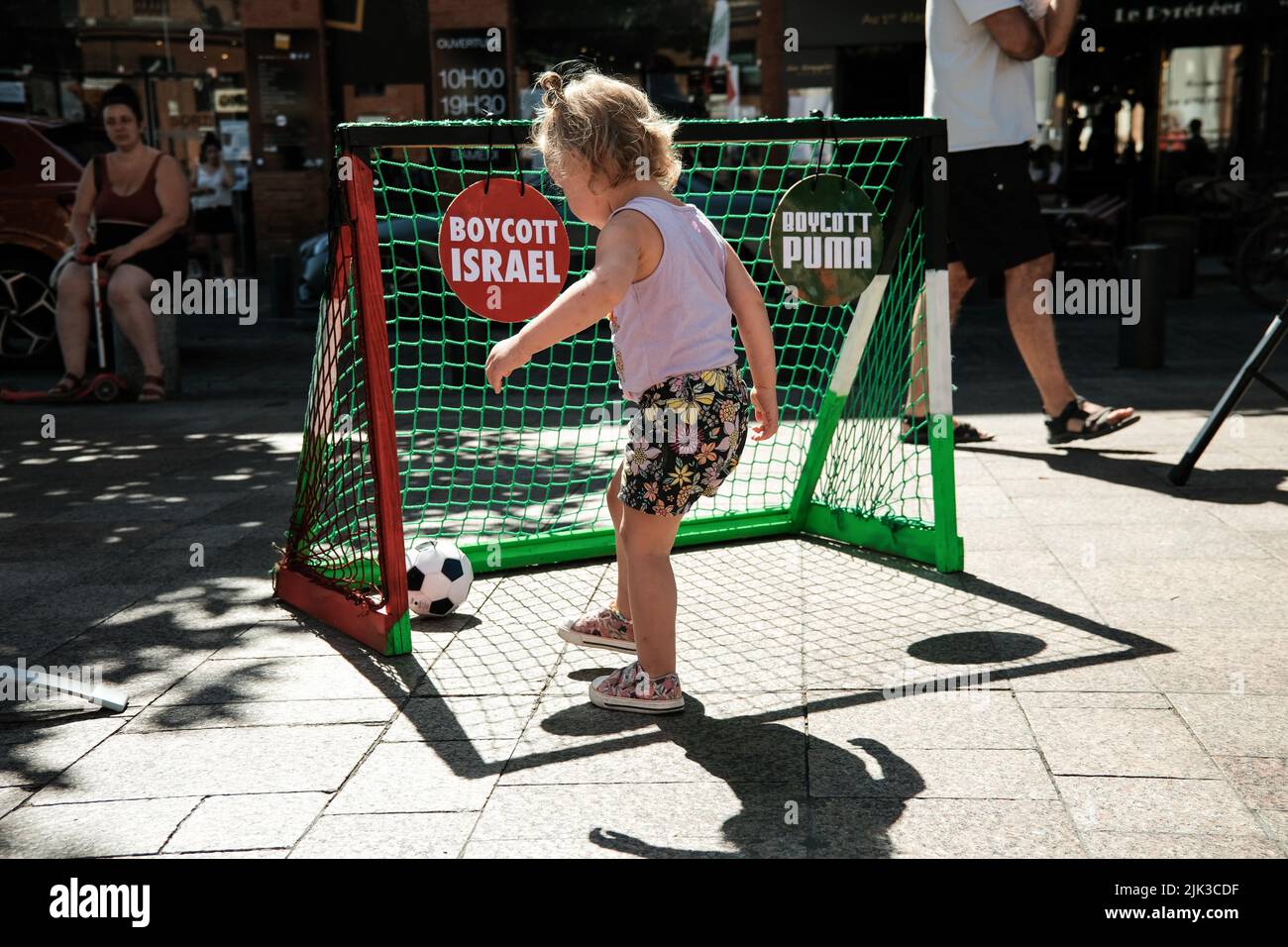 Tolosa, Francia. 30th luglio 2022. Una bambina spara al traguardo del calcio, con i segni 'Boycott Israel' e 'Boycott Puma'. Su invito del Collectif Palestine Vaincra, riabilitato dal Consiglio di Stato alcune settimane fa, diversi attivisti hanno organizzato un punto di informazione per il boicottaggio del Champions Trophy (Trophée des Champions), e più in generale dei prodotti israeliani. Il Champions Trophy è una partita di calcio tra il PSG (campione della Ligue 1) e il FC Nantes (vincitore della Coupe de France) il 31 luglio 2022 a Tel Aviv (Israele). Per il collettivo, questo trofeo è un'operazione commerciale o Foto Stock