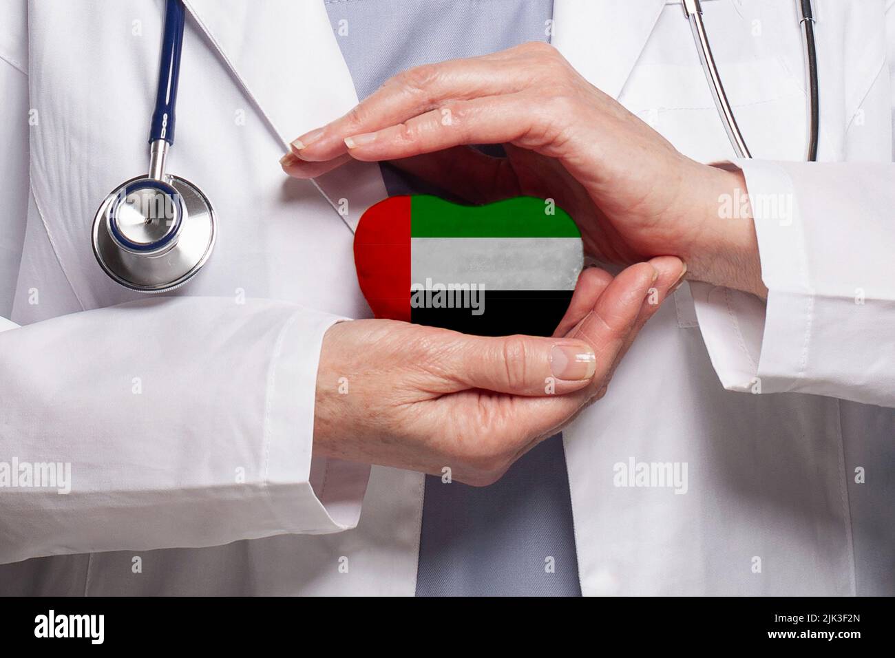 OAE medico tenendo cuore con bandiera di sfondo Emirati Arabi Uniti.  Concetto di assistenza sanitaria, beneficenza, assicurazione e medicina  Foto stock - Alamy