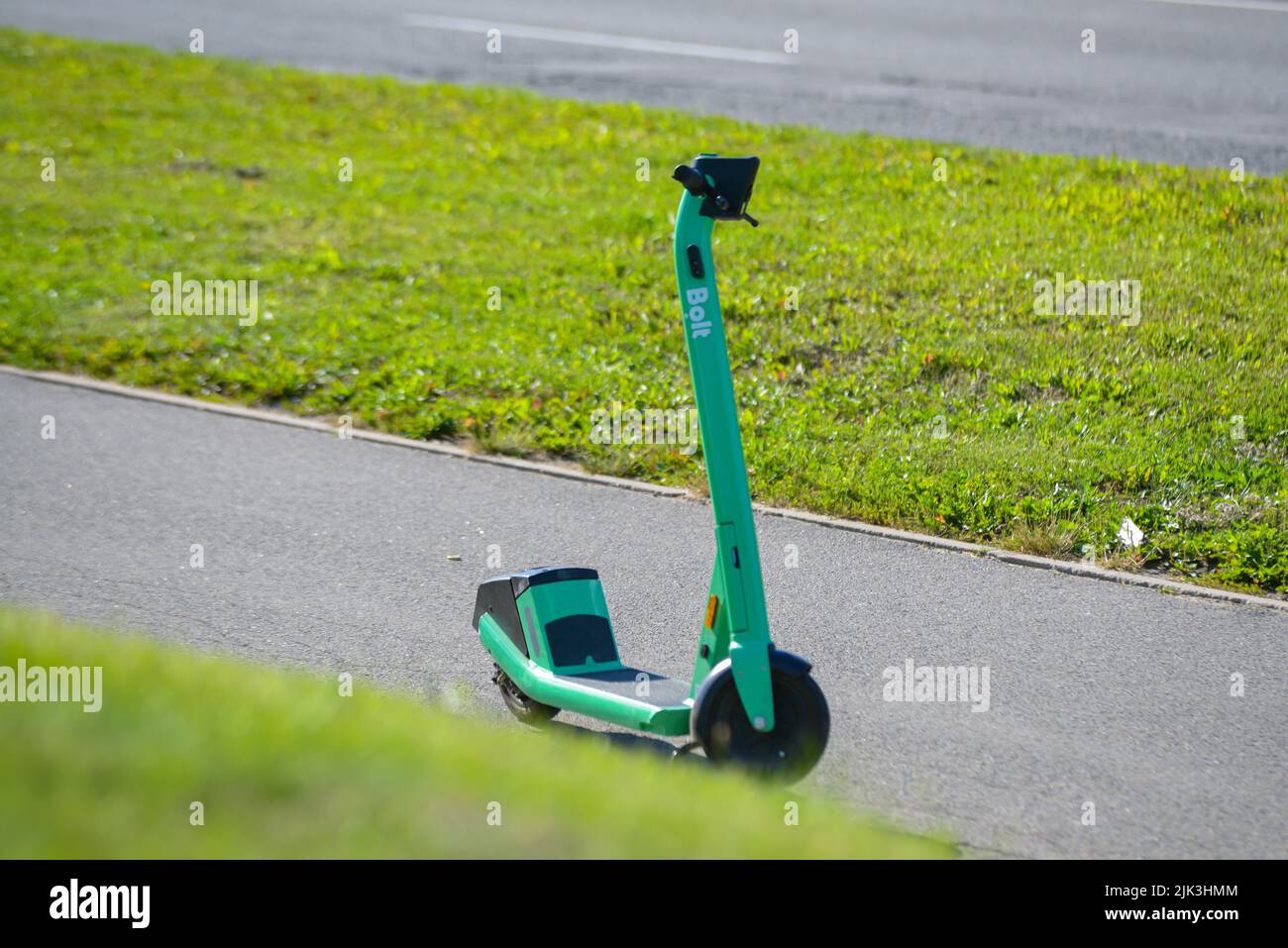 Riga, Lettonia - 29.07.2022: Un nuovo E-scooter BOLT parcheggiato sul marciapiede, pedoni inquietanti. Foto Stock