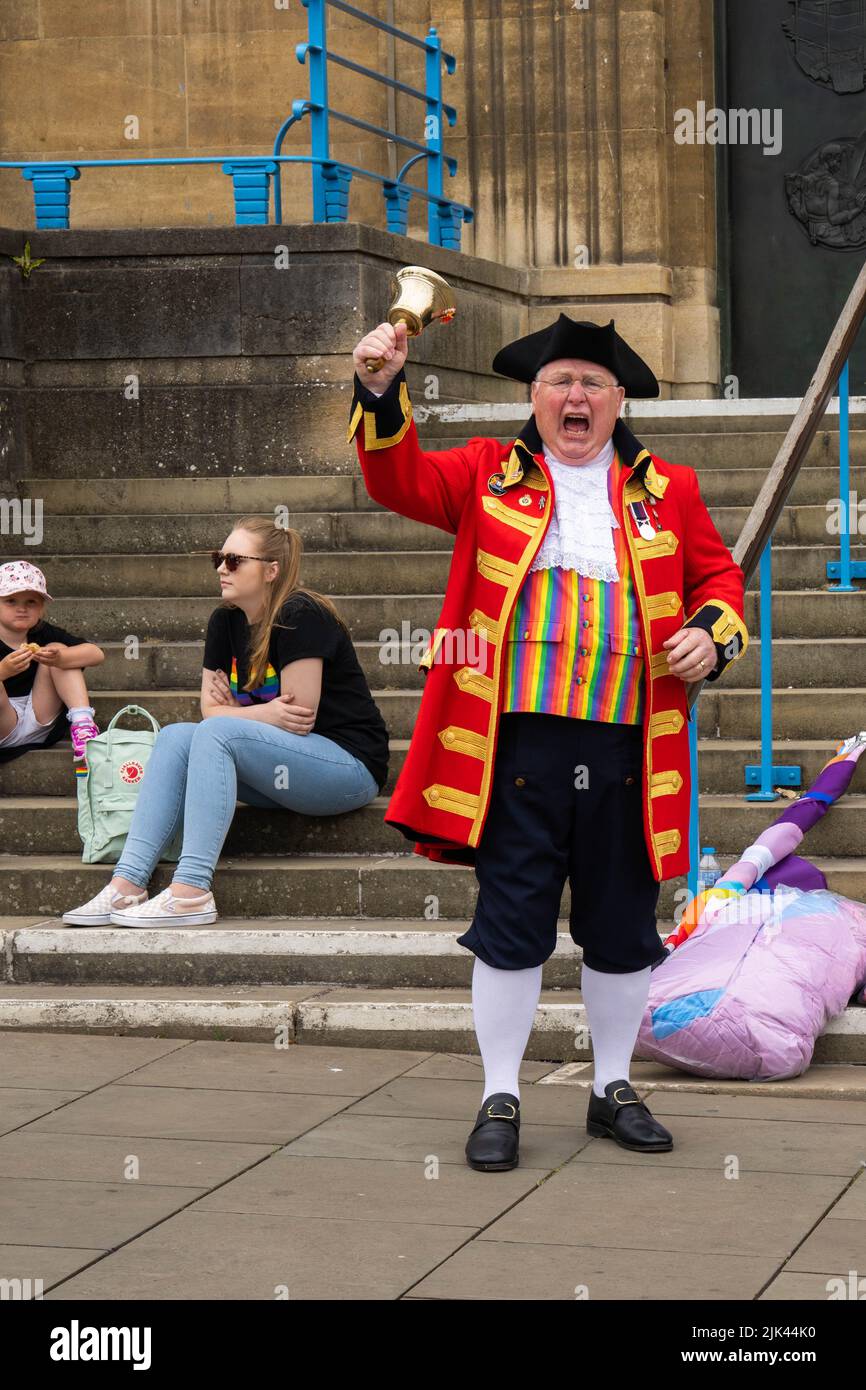 Il grido della città si trova fuori dal municipio di Norwich scuotendo la sua campana per l'inizio della marcia LGBT Pride Foto Stock
