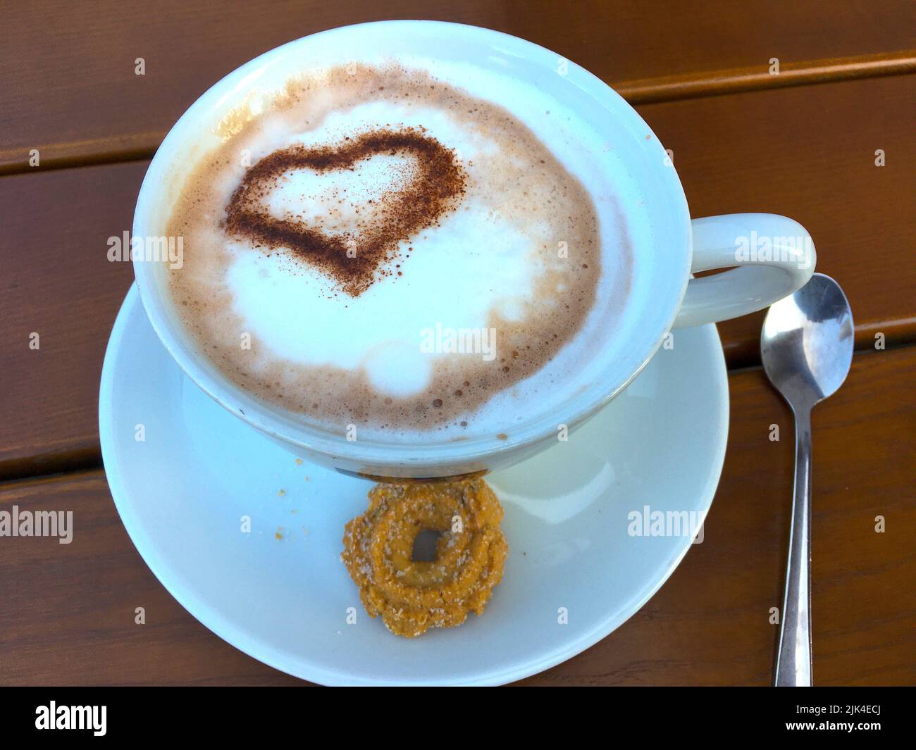 Tasse Cappuccino mit einem Herz aus Kakao verziertem Milchschaum Foto Stock