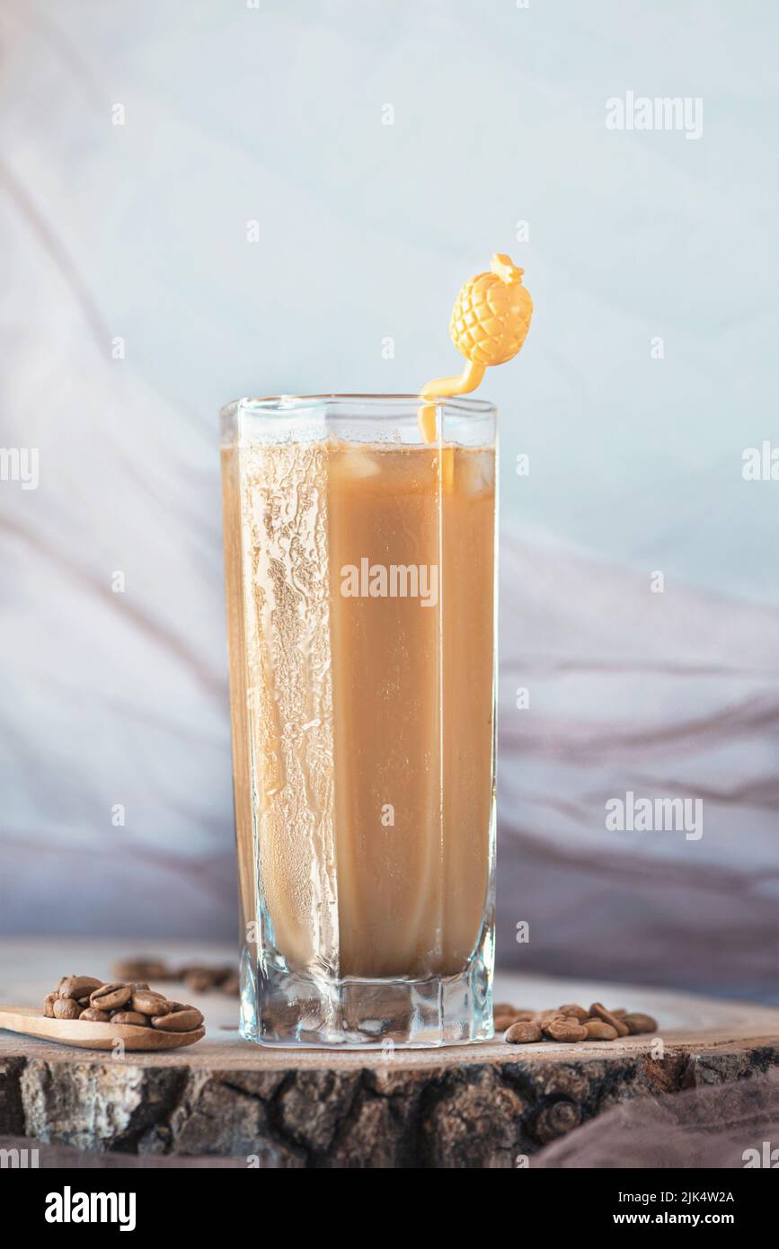 Delizioso latte ghiacciato su un piatto di servizio in legno con chicchi di caffè, primo piano, fotografia di natura morta Foto Stock