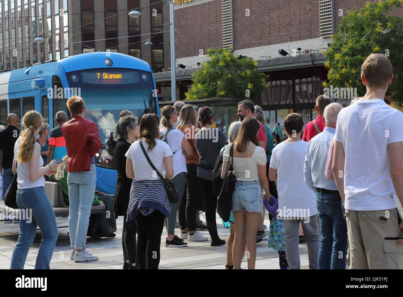 Stoccolma, Svezia - 29 luglio 2022: Persone in attesa alla fermata affollata del tram T-Centralen per il tram dei mezzi pubblici sulla linea 7 per lo Skansen out Foto Stock