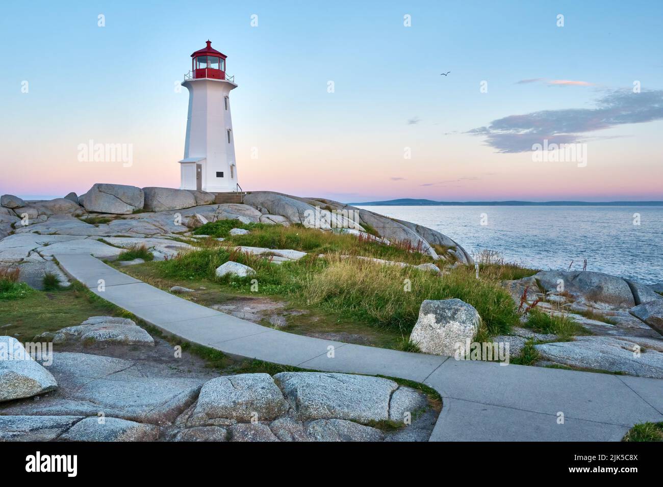 Foto dell'iconico faro di Peggy's Cove scattata all'alba in una bella mattinata estiva. Foto Stock