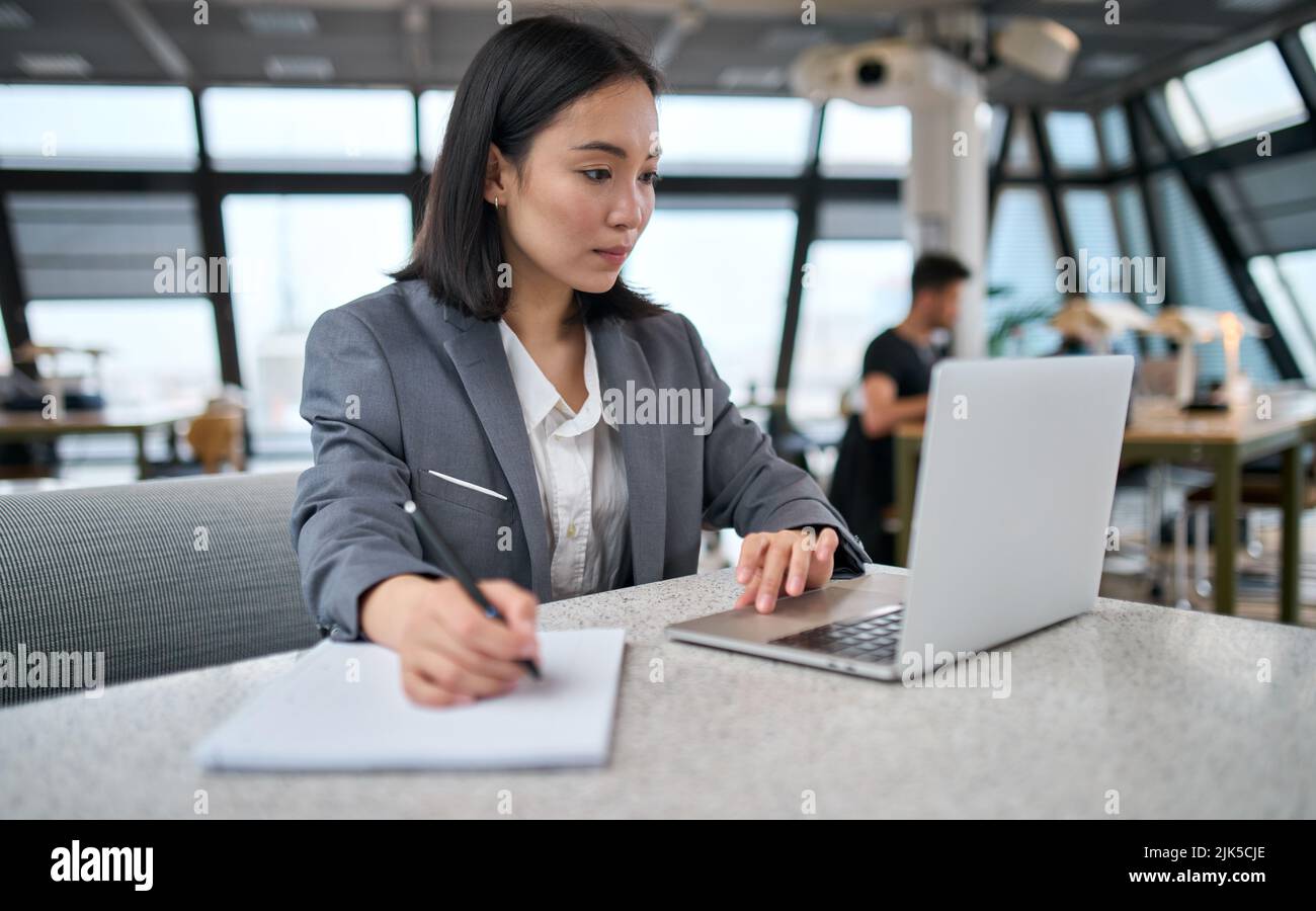 Giovane donna d'affari asiatica dipendente d'ufficio che utilizza il webinar di osservazione dei notebook. Foto Stock