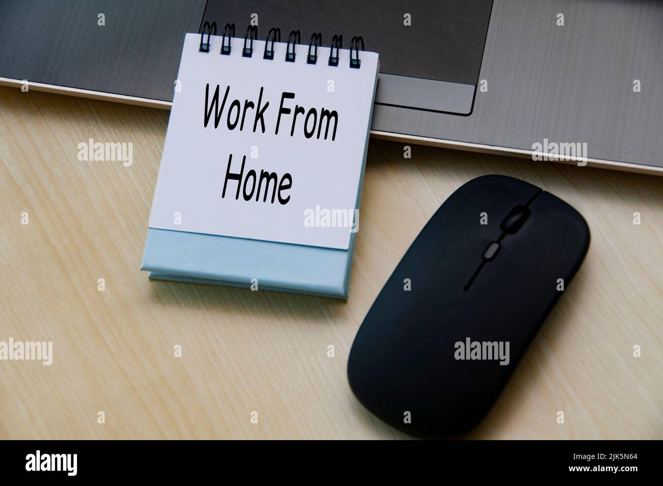 Vista dall'alto del testo su blocco note - lavoro da casa. Con computer portatile e mouse su sfondo in legno. Concetto aziendale. Foto Stock