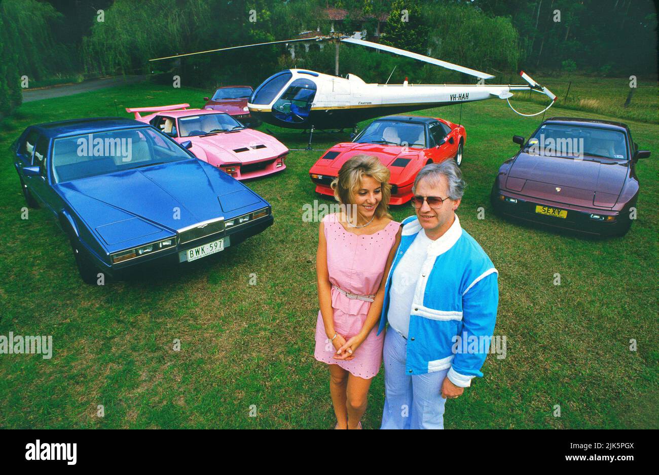 Flamboyant Doctor, il defunto Geoffrey Edelsten e la sua moglie di 19 anni, Leanne, fotografati con le loro auto e elicottero sul terreno della loro casa di Sydney nel 1983 Foto Stock