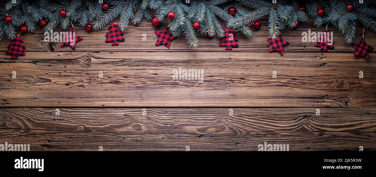 Accogliente spazio copia sfondo con rami di abete rosso e ornamenti di alberi di Natale su legno di fienile Foto Stock