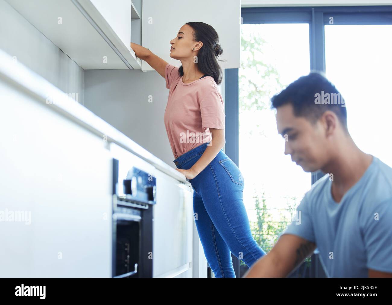 Una giovane coppia pulisce la propria cucina insieme. Foto Stock