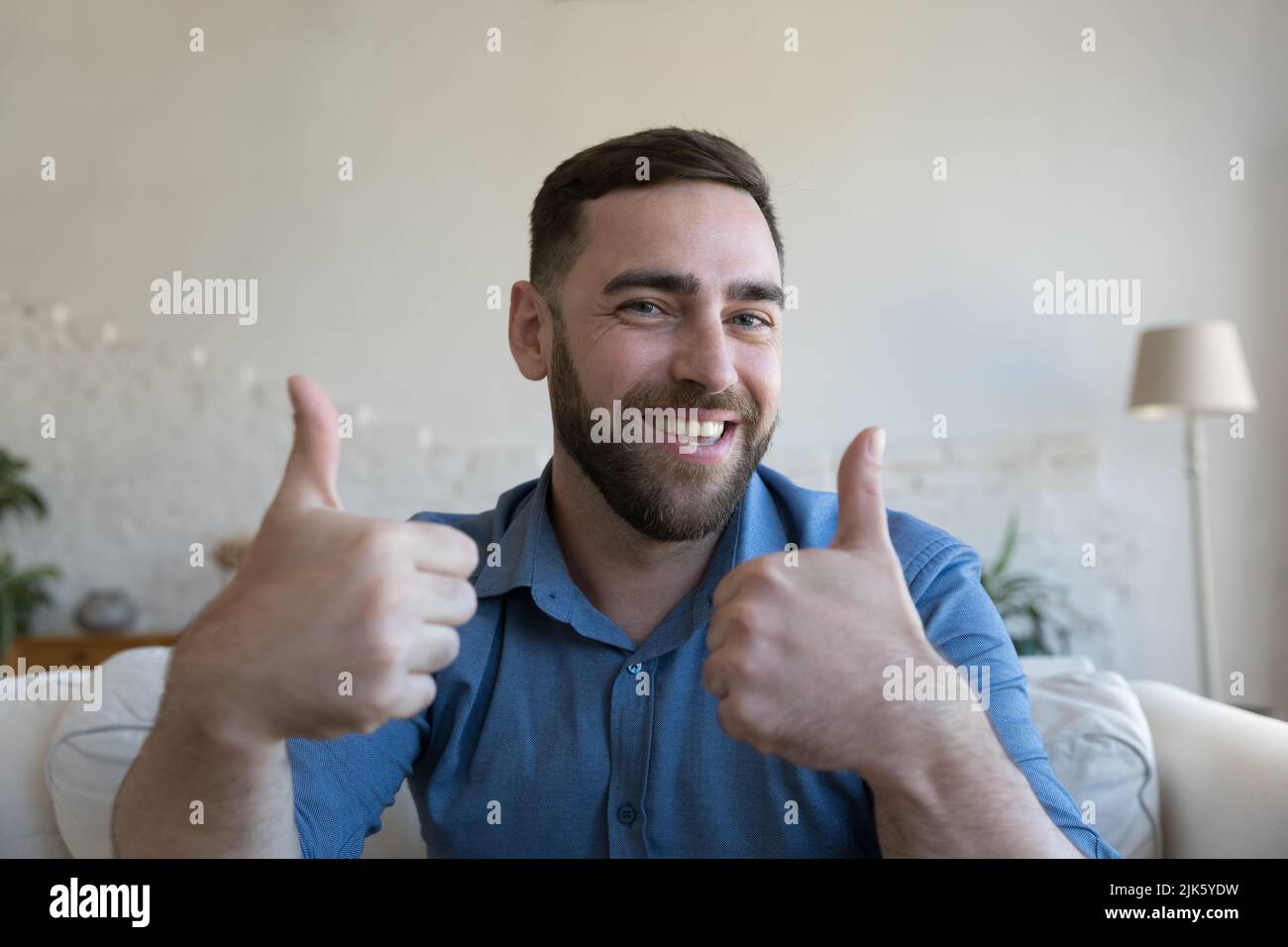 Allegro felice adulto 30s ragazzo mostrando come pollice su mani Foto Stock