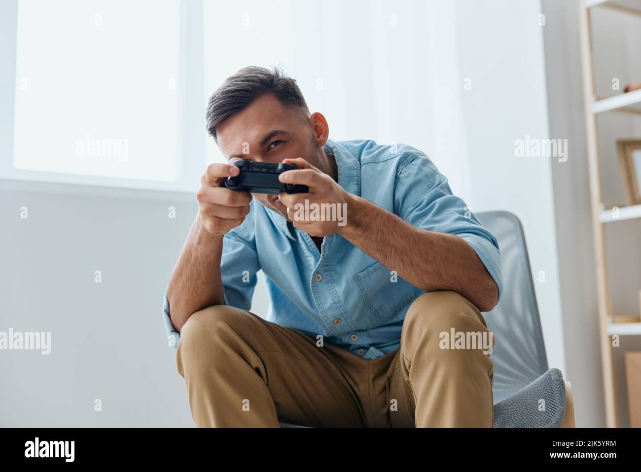 Piattaforma Player Stream per i gamer. Il gamepad con joystick concentrato per i giovani giocatori in scatola tiene da parte lo schermo a casa. Attività rilassante Foto Stock