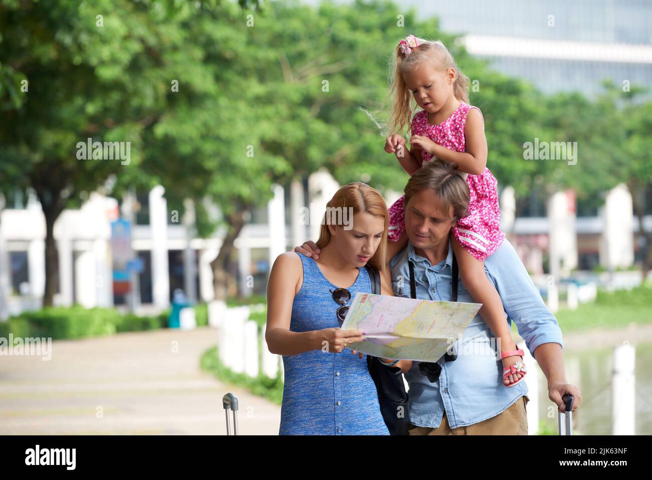 Famiglia di viaggiatori alla ricerca di hotel sulla mappa della città Foto Stock