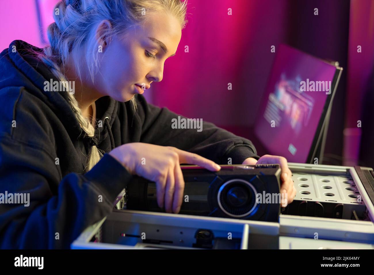 Primo piano di Gamer Girl Installazione di una nuova scheda video GPU in Il suo PC da gioco Foto Stock