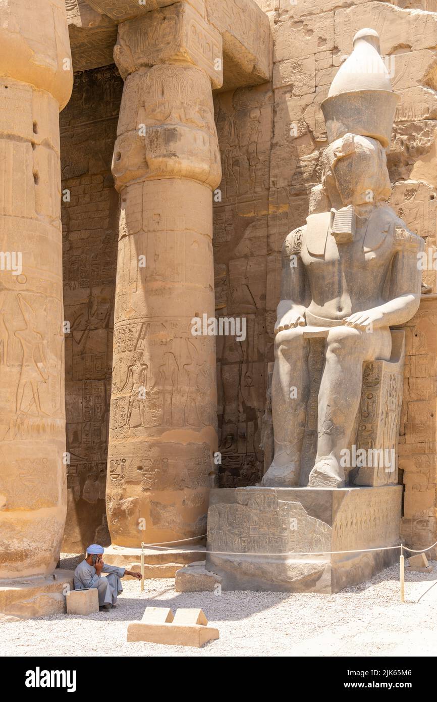 Luxor, Egitto; 28 luglio 2022 - un uomo arabo siede all'ingresso del Tempio di Luxor, Egitto. Foto Stock