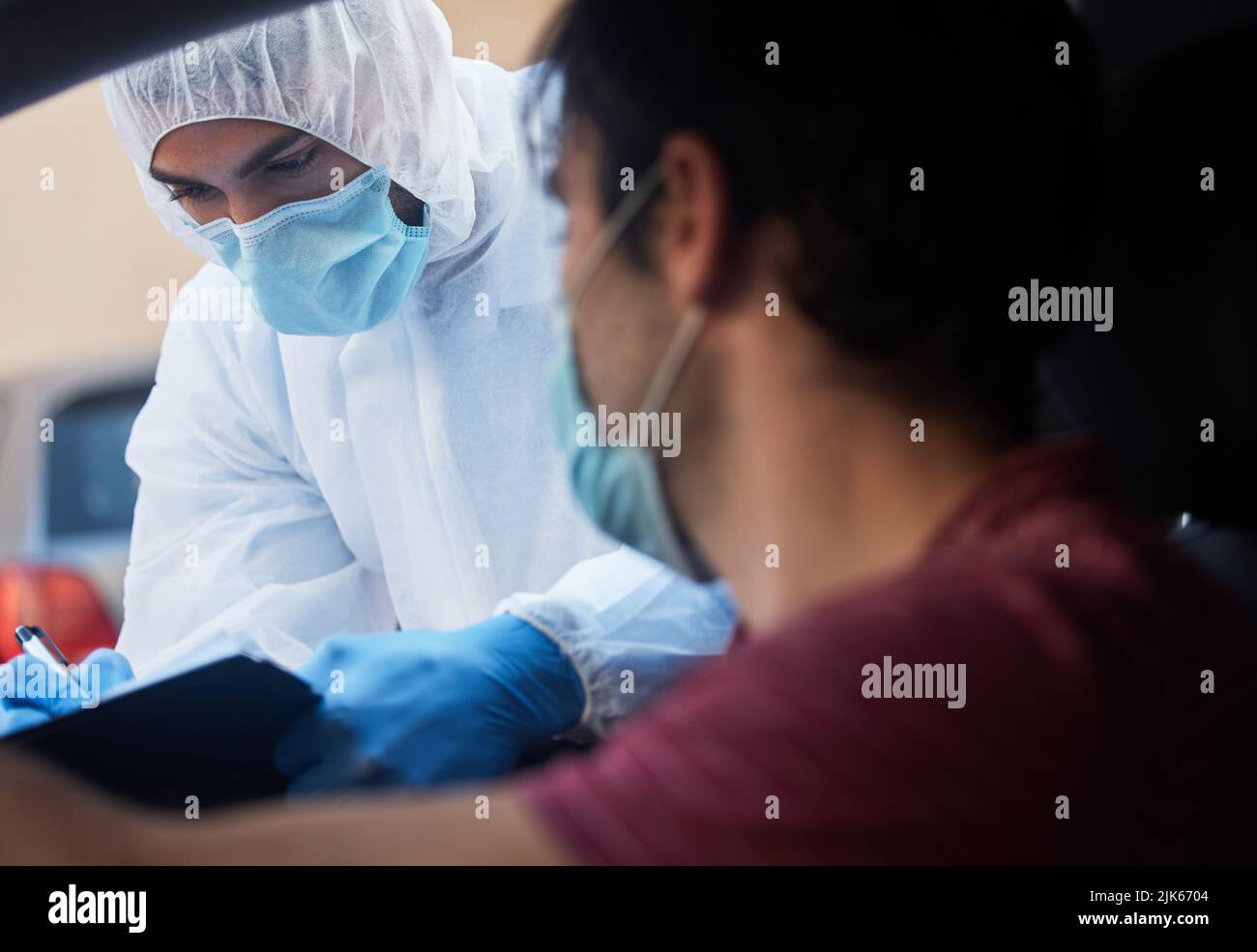 Non ho sintomi medico. Un medico che registra un paziente informazioni per una guida attraverso la vaccinazione. Foto Stock