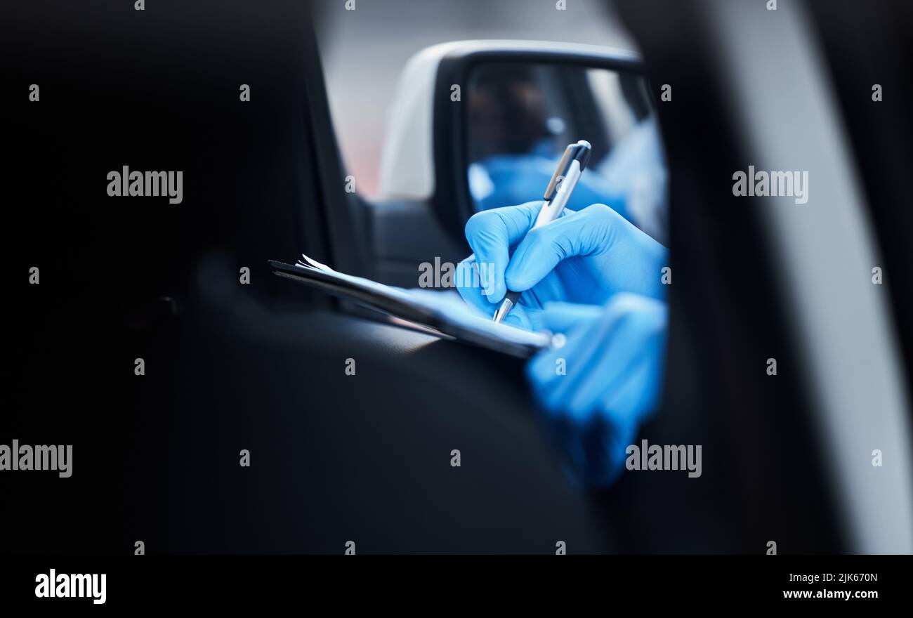Si prega di compilare il modulo in modo accurato. Un medico che registra le informazioni di un paziente per una vaccinazione di tipo drive-through. Foto Stock