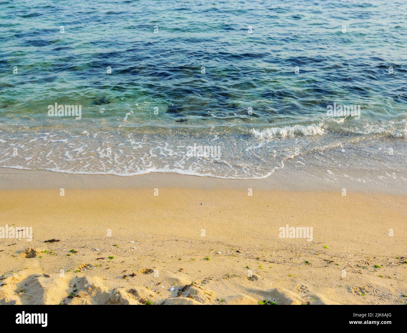 spiaggia di mare in luce di mattina. sfondo natura di spiaggia sabbiosa e acqua calma trasparente in estate Foto Stock