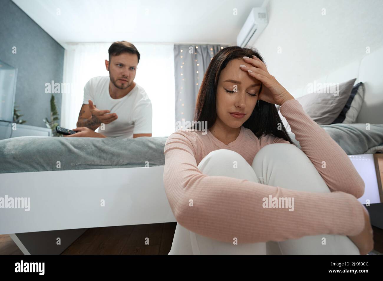 Spiacevole disputa tra uomo e donna in camera da letto familiare Foto Stock
