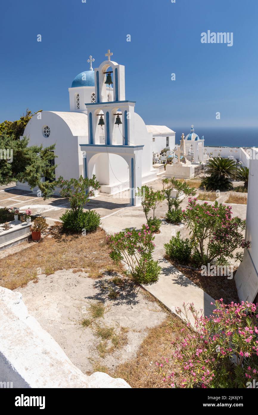Bella chiesetta bianca con cupola blu, campanile e cimitero. A pochi metri dalla Chiesa di Agios Charalambos, Exo Gonia Santorini, Grecia. Foto Stock