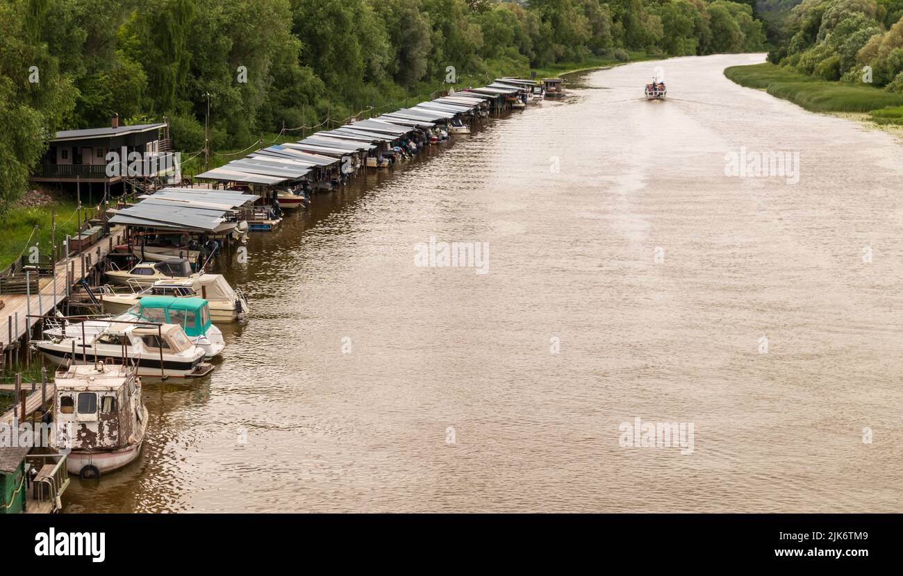Il fiume con tagliatori nel porto lungo il bordo del fiume Foto Stock