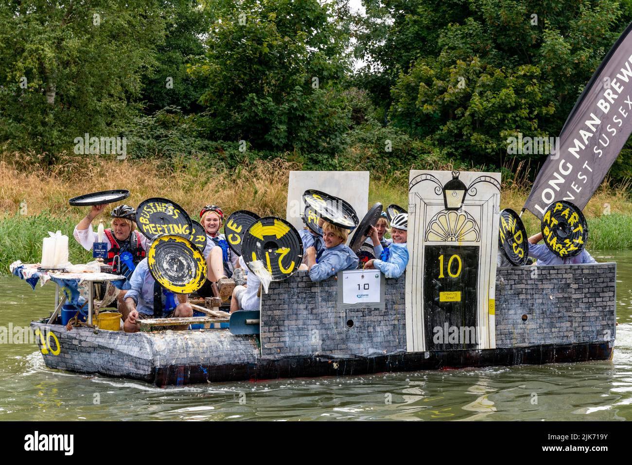 Lewes, Regno Unito. 31st luglio 2022. La gente del posto in zattere fatte in casa partecipa alla corsa di Lewes Raft sul fiume Ouse da Lewes a Newhaven. La Raft Race è un evento annuale organizzato da Lewes Round Table in aiuto di enti di beneficenza locali. Tradizionalmente, gli spettatori si allineano sulla riva del fiume e gettano uova e farina alle zattere con la gente sulle zattere proteggendosi con scudi fatti in casa. Credit: Grant Rooney/Alamy Live News Foto Stock