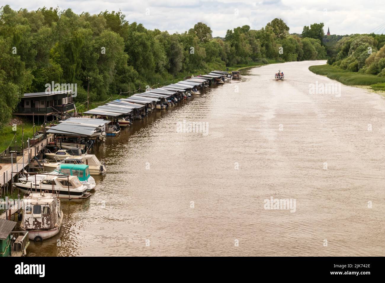 Il fiume con tagliatori nel porto lungo il bordo del fiume Foto Stock