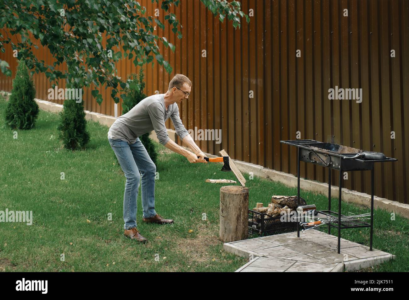 Il abitante della città prepara la legna per un barbecue nella sua casa di campagna Foto Stock