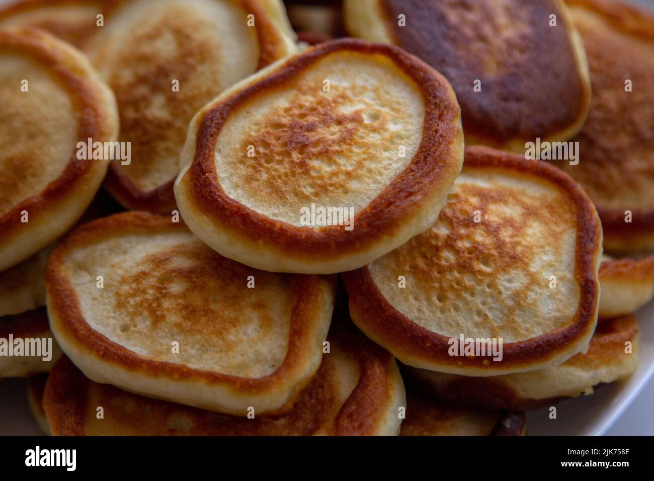 Primo piano su freschi e soffici pancake fatti in casa sul piatto. Pronto a mangiare panetteria per la prima colazione. Foto Stock