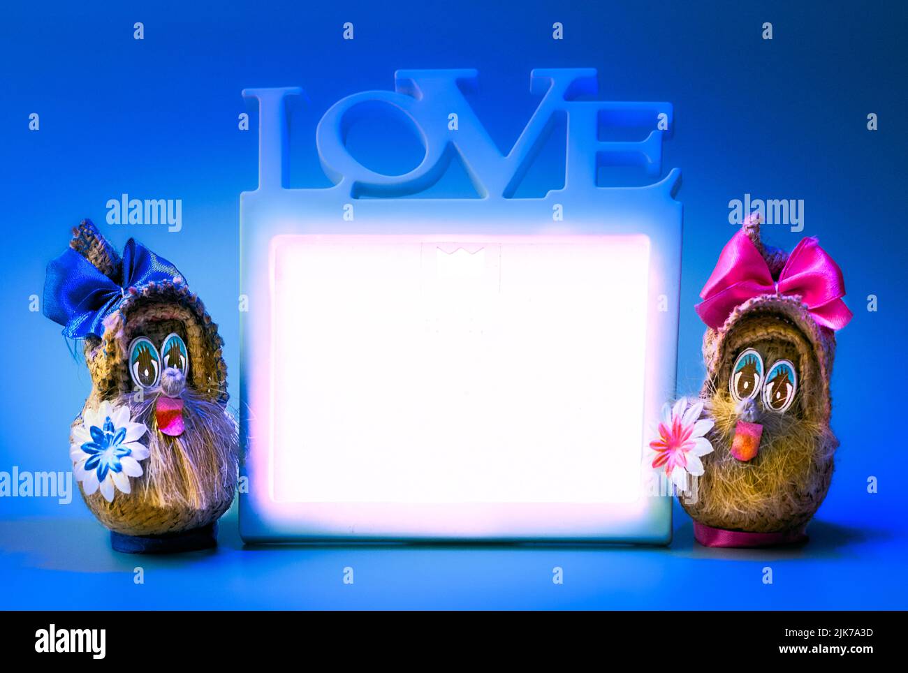 Due divertenti gnomes e cornice d'amore su sfondo blu Foto Stock
