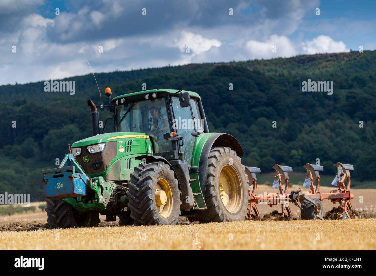 Aratura in stoppie su un campo arabile con un trattore John Deere 6155M e un aratro reversibile a 5 solchi. North Yorkshire, Regno Unito. Foto Stock