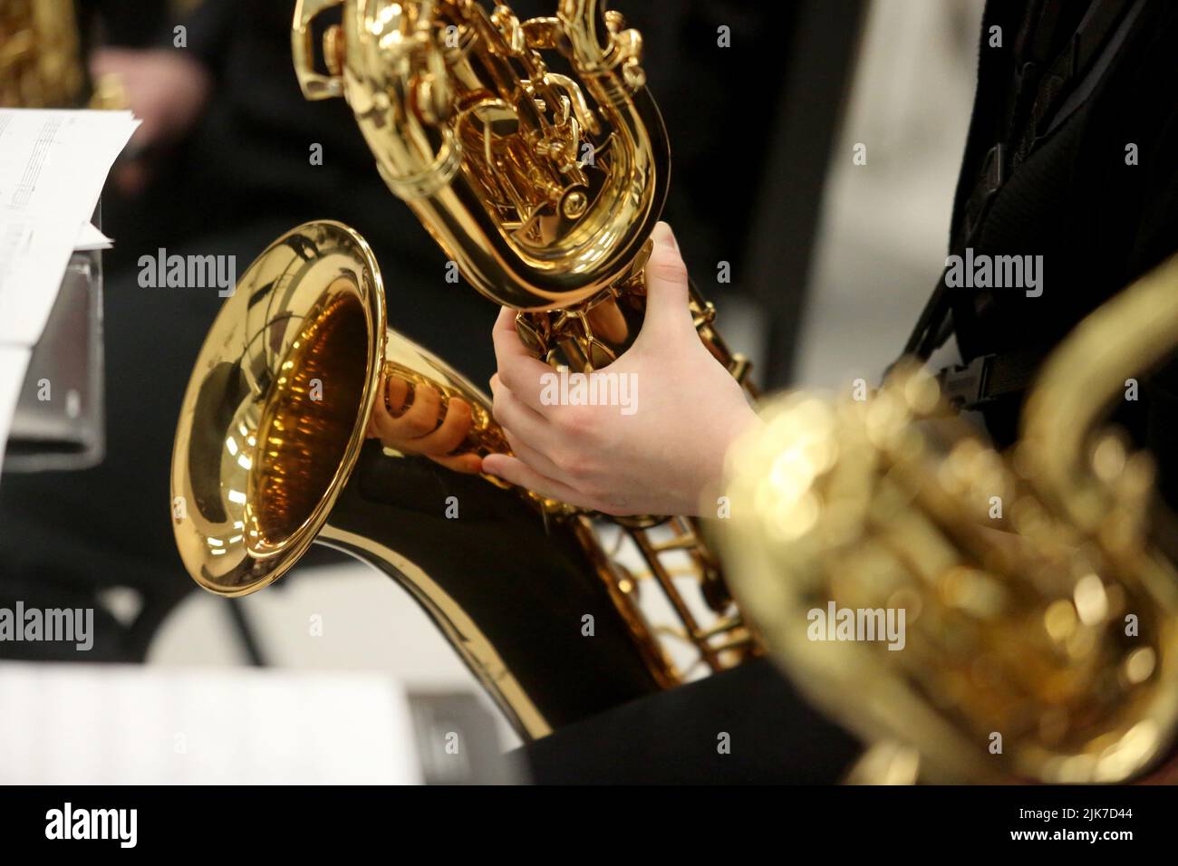 Un primo piano delle mani di un musicista che suona un sassofono baritono. Foto Stock