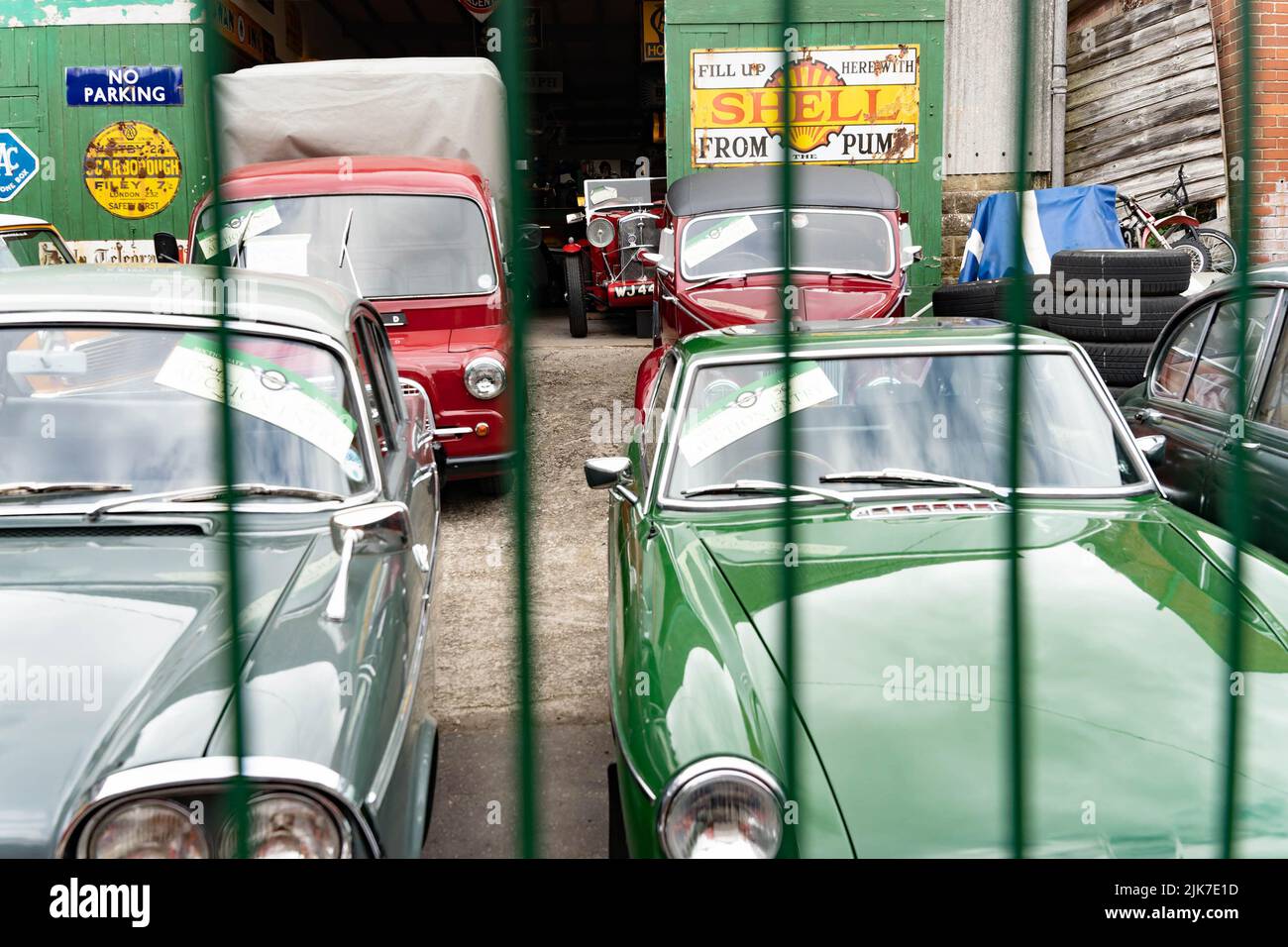 Auto d'epoca d'epoca custodite in garage con segnaletica per stazione di servizio Shell Foto Stock