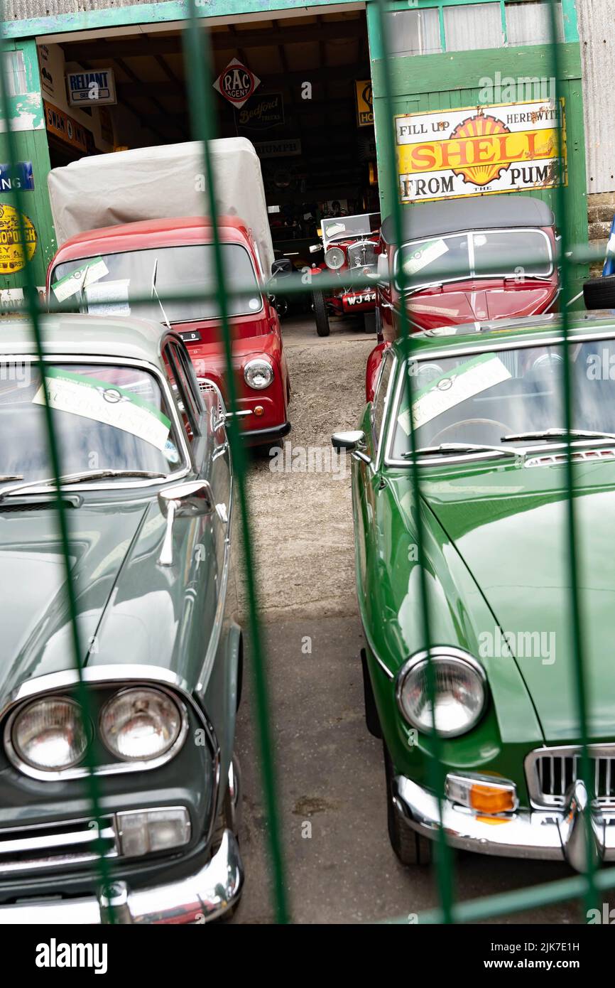 Auto d'epoca nel piazzale storico del garage con segnaletica per stazione di servizio d'epoca Foto Stock