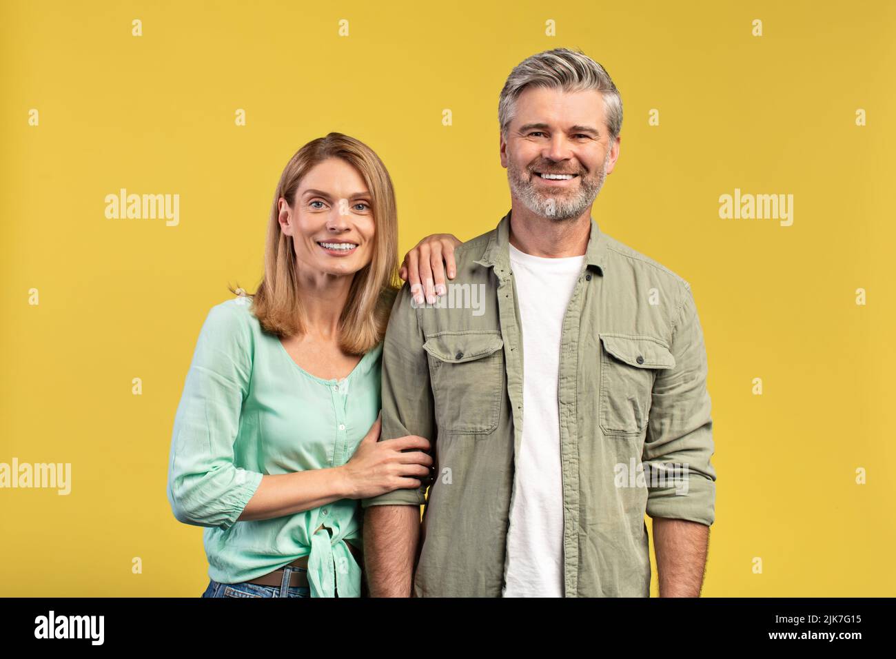 Coppia matura romantica. Ritratto di felice uomo e donna europeo di mezza età in posa su sfondo giallo Foto Stock