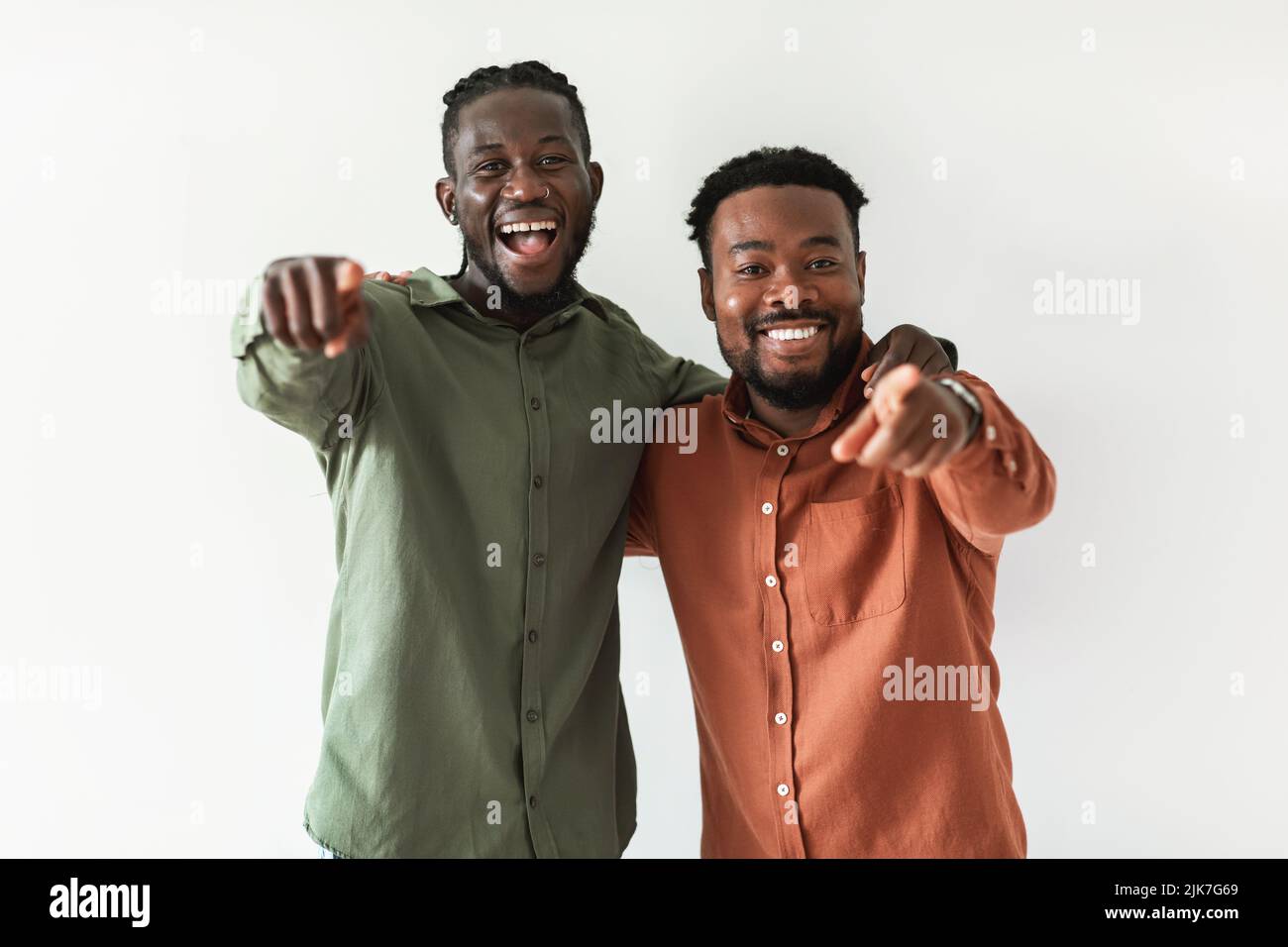 Due Happy African Guys puntano le dita alla fotocamera, sfondo bianco Foto Stock
