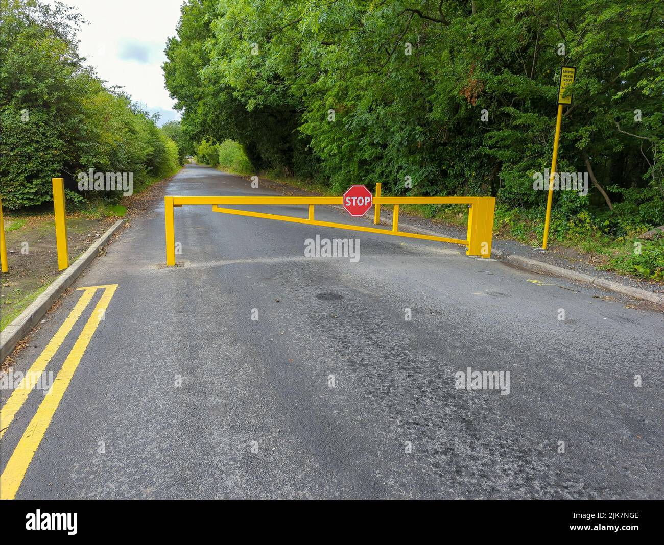Cancello di sicurezza giallo che limita l'accesso a una strada Foto Stock