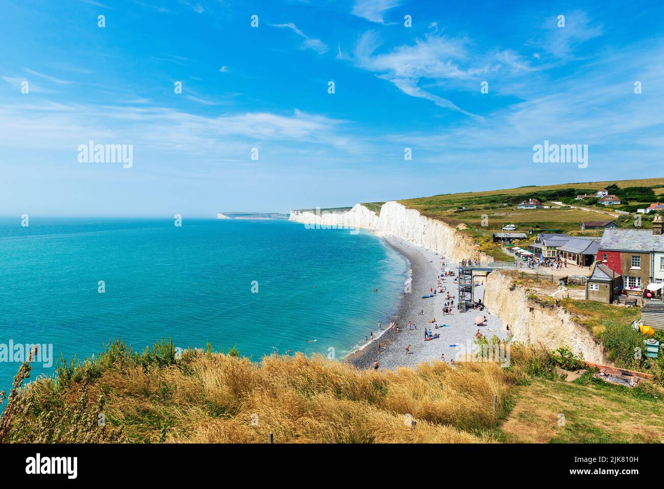 Una vista della spiaggia e le Sette Sorelle le scogliere su un pomeriggio estivo a Birling Gap, East Sussex, Regno Unito Foto Stock