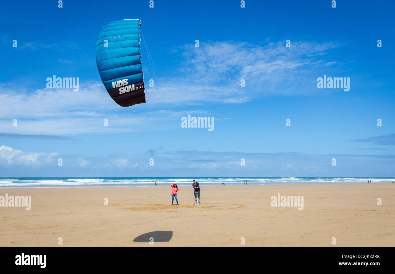 Beach kite board kite formazione. Un uomo insegna alla sua ragazza come volare un aquilone di potere in una giornata estiva soleggiata e ventosa su una bella spiaggia in Cornovaglia Foto Stock
