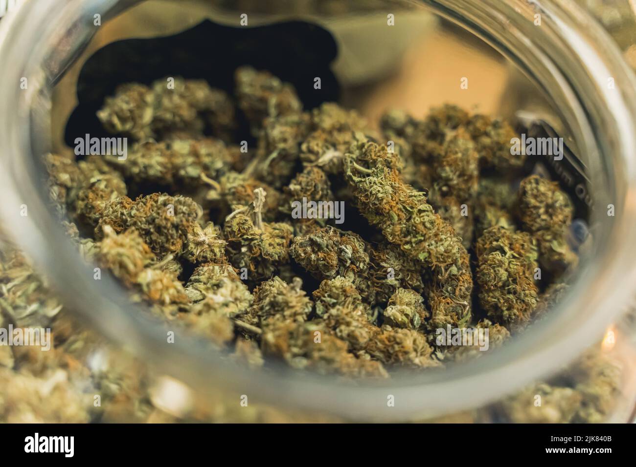 Primo piano di boccioli di cannabis secchi e tagliati conservati in un vaso di vetro trasparente. Concetto di medicina alternativa. Ansia sollievo. Foto di alta qualità Foto Stock